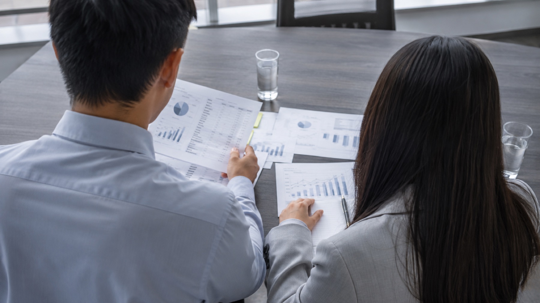 Two colleagues reviewing documents together at a table